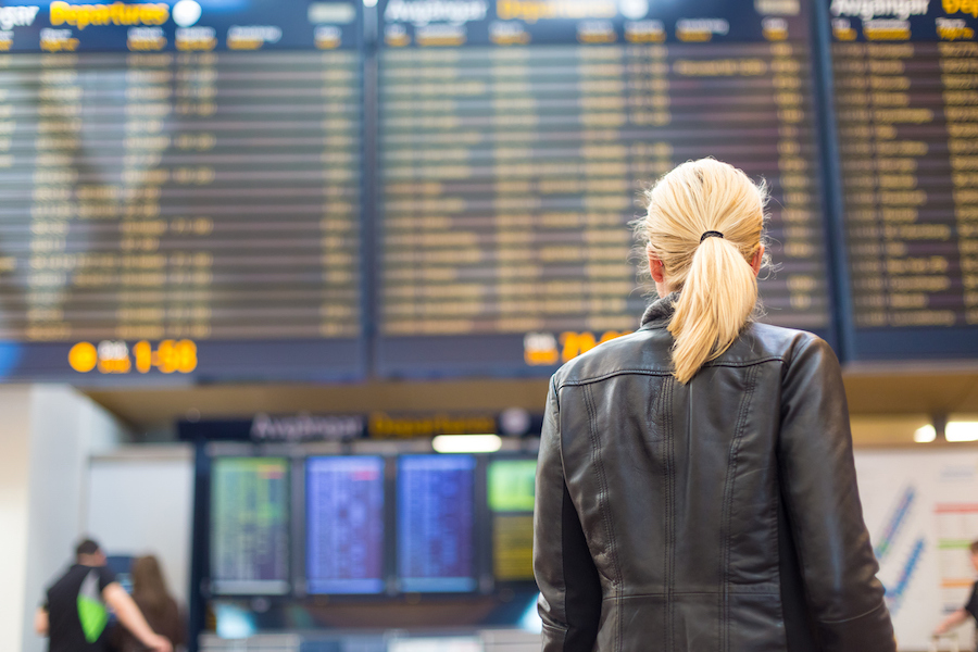 woman looking at departure board at airport